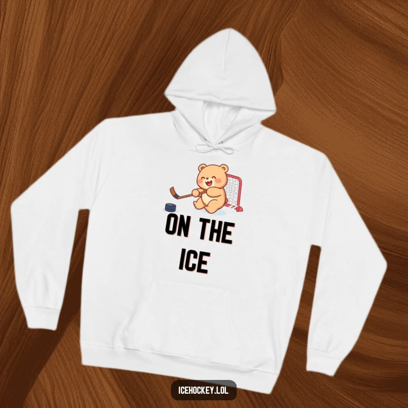 Funny hoodie with a joyful, round bear cub skillfully shooting a hockey puck, offering warmth and humorous sports enthusiasm.