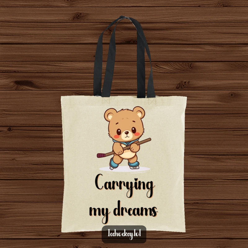 Funny tote bag featuring a curious bear cub hilariously attempting to skate with an oversized hockey stick.